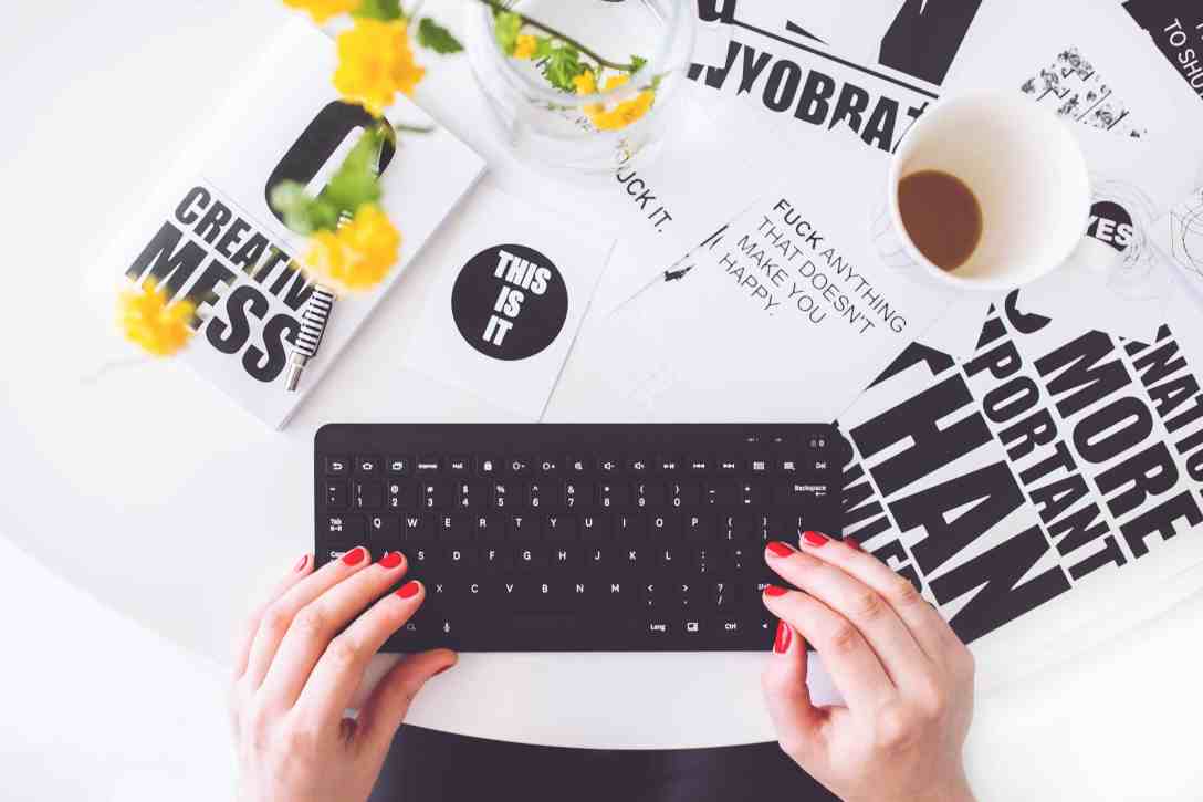 photo rédaction web mains vernis rouge sur un clavier